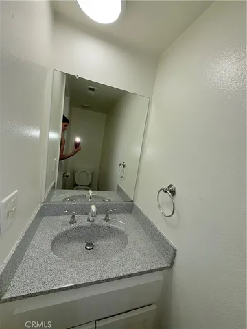 a bathroom with a granite countertop sink and a mirror