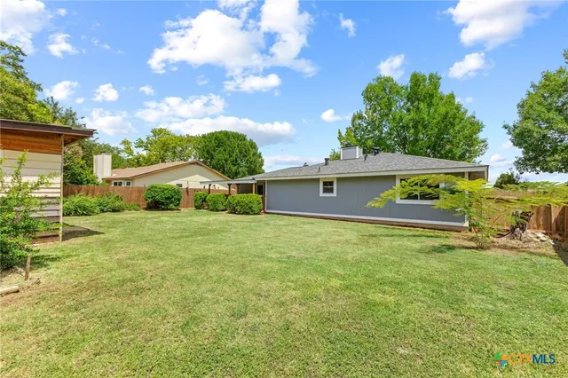 a view of an house with backyard space and garden