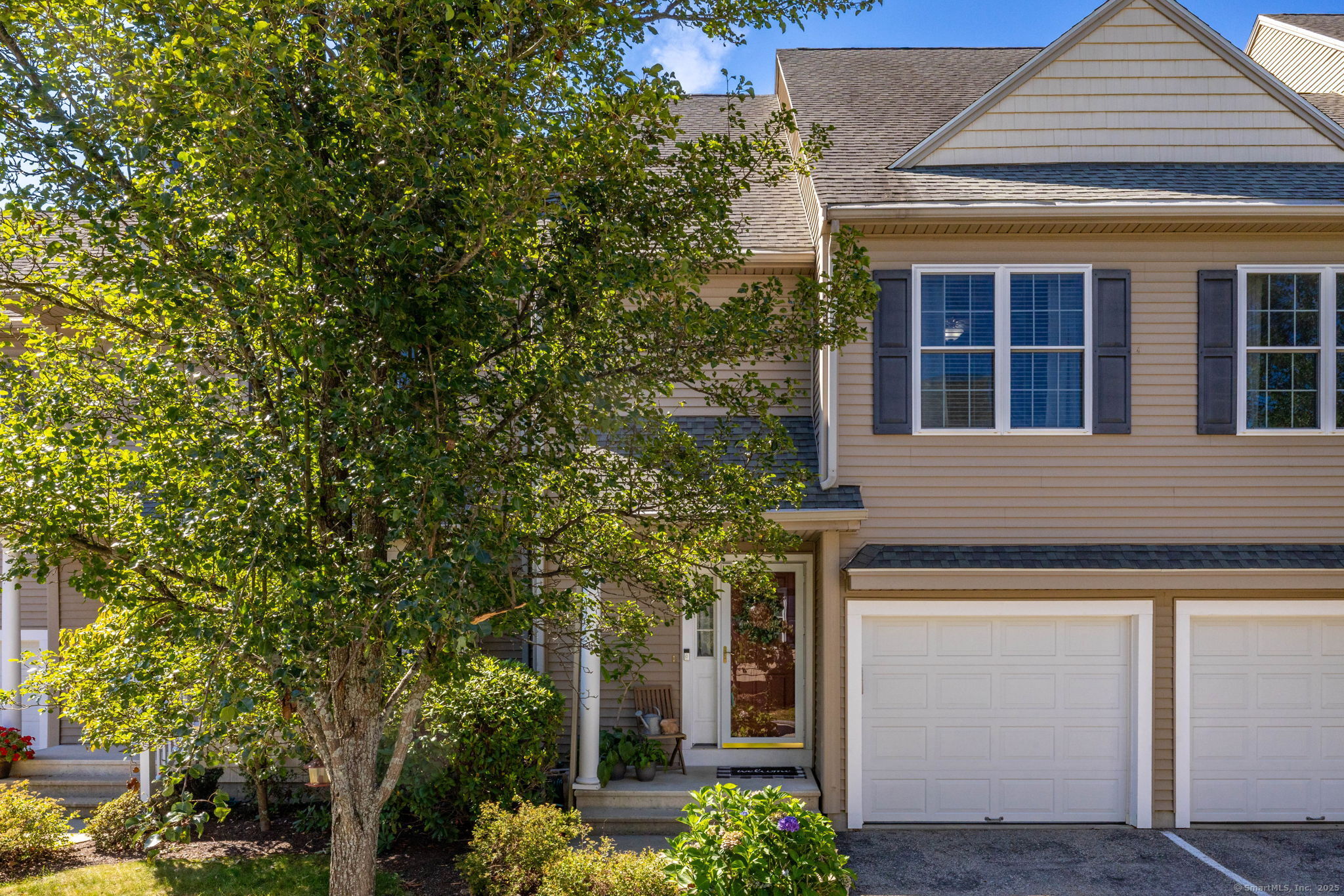 a front view of a house with a tree