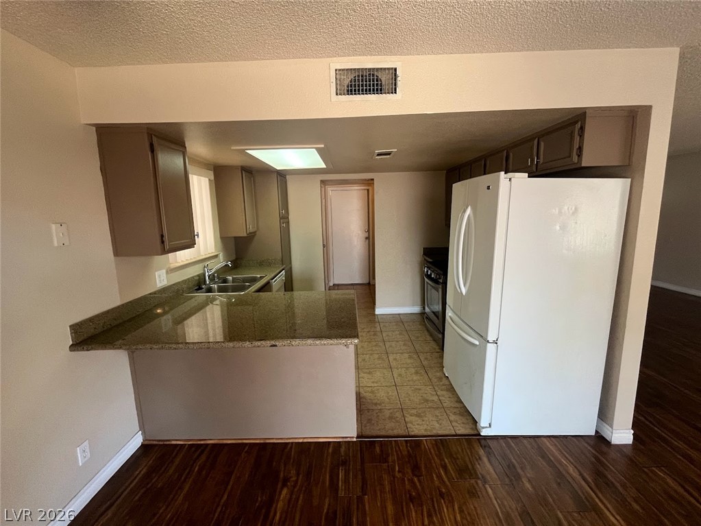 914 Scarlet Ridge Drive Las Vegas, NV 89128 - Photo 8 of 25 A well-lit kitchen with granite countertops offers practicality and a welcoming atmosphere for daily living.