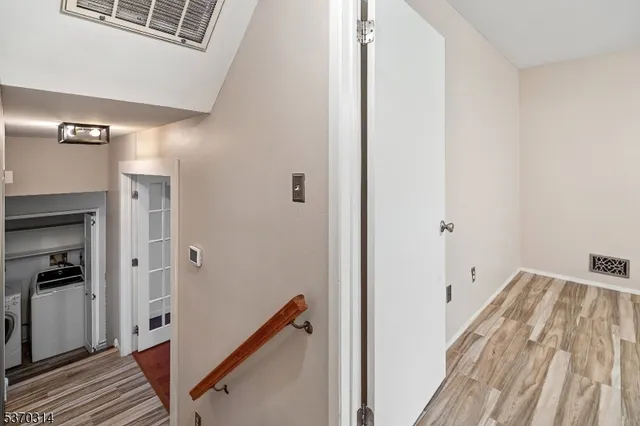 a view of a hallway with wooden floor and staircase