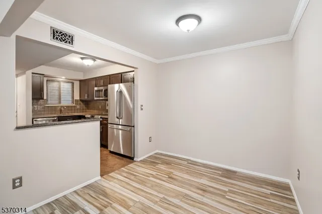 a view of a kitchen with a sink and refrigerator