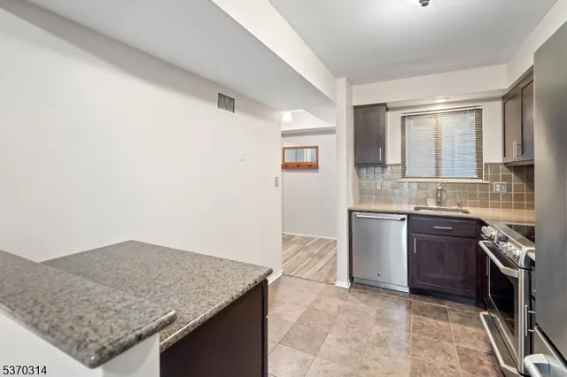 a kitchen with granite countertop a sink and a stove