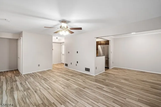 a view of a room with wooden floor and white walls
