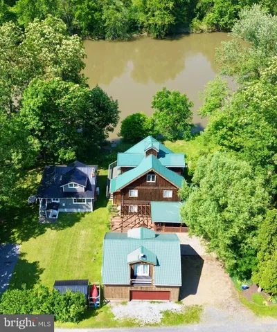 an aerial view of a house with swimming pool and lake view