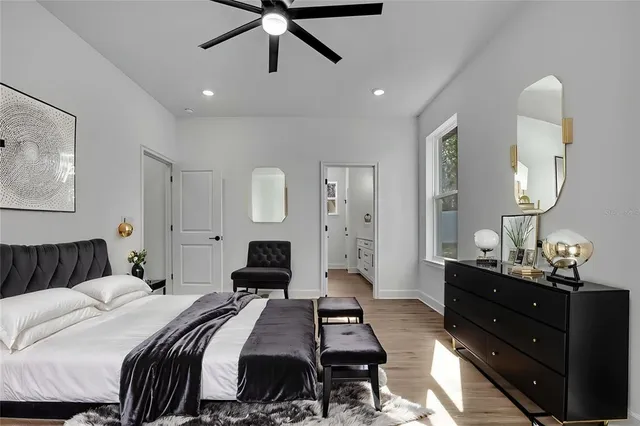 an empty room with wooden floor and ceiling fan