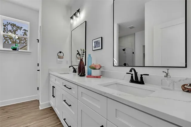 a bathroom with double sink a mirror and vanity