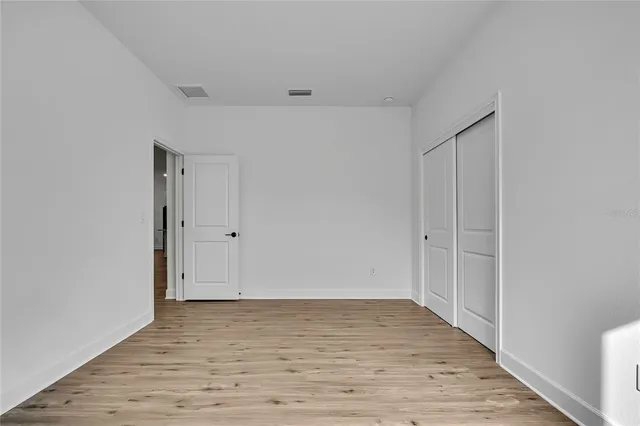 an empty room with wooden floor and a window