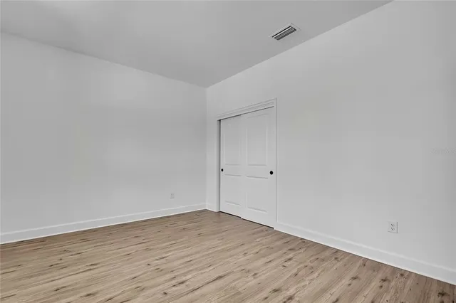 a view of a closet area with hardwood floor