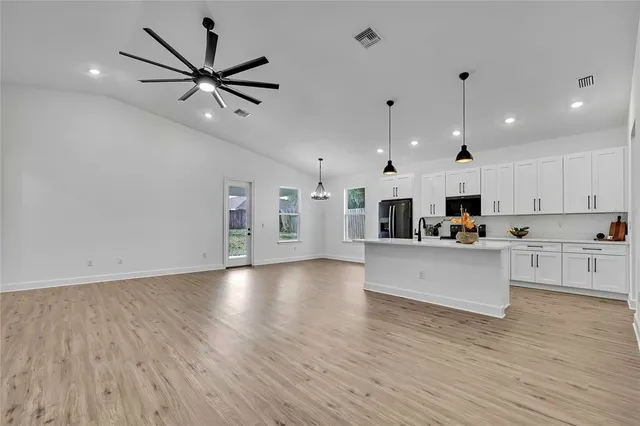 a view of a kitchen with cabinets stainless steel appliances a sink and a window