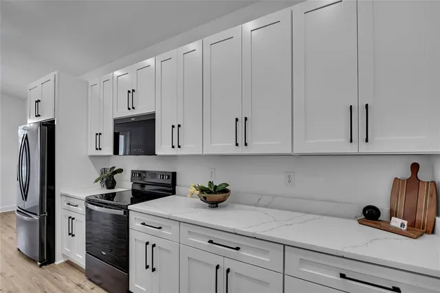 a kitchen with white cabinets and stainless steel appliances
