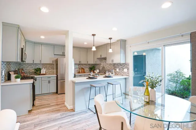 a kitchen with a refrigerator a stove a sink dishwasher with a dining table and chairs