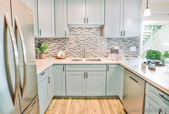 a kitchen with stainless steel appliances a refrigerator sink and cabinets