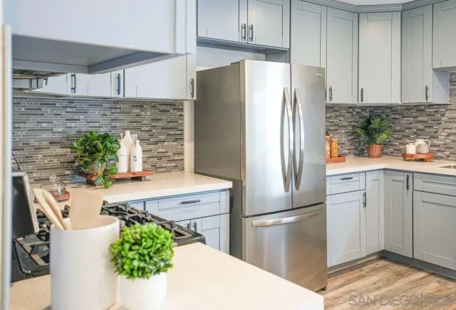 a kitchen with stainless steel appliances a refrigerator sink and wooden cabinets