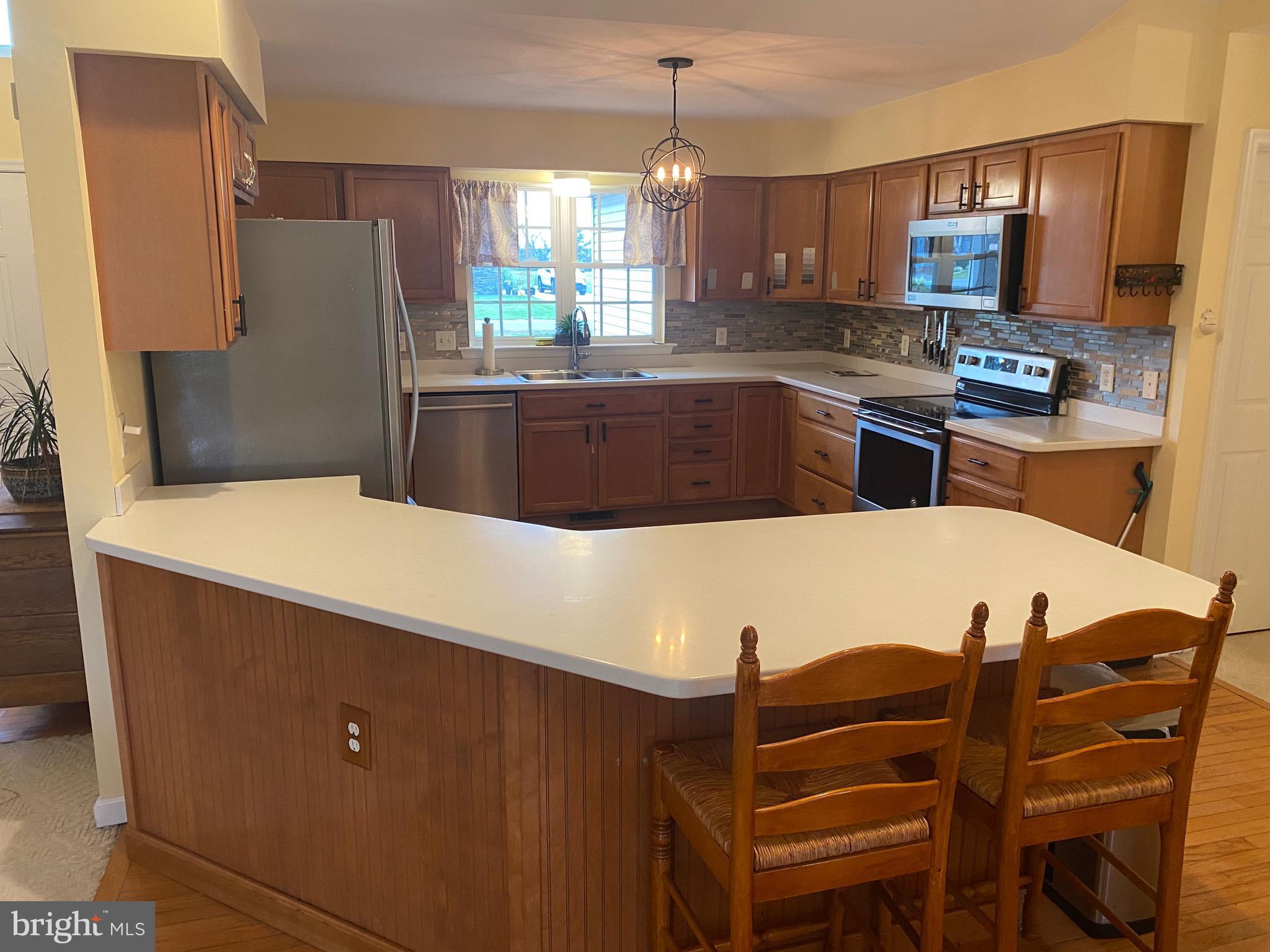 13 Fairway Avenue Georgetown, DE 19947 - Photo 21 of 37 a kitchen with stainless steel appliances a refrigerator a sink a stove a dining table and chairs
