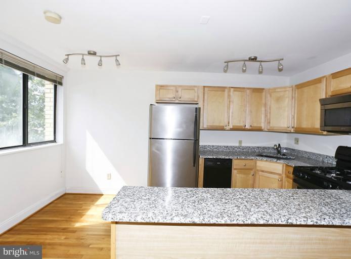 a kitchen with stainless steel appliances granite countertop a sink refrigerator and microwave