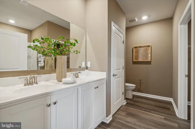 a bathroom with a granite countertop sink a toilet and a mirror