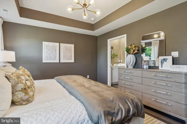 a bedroom with a large bed and a mirror on dresser