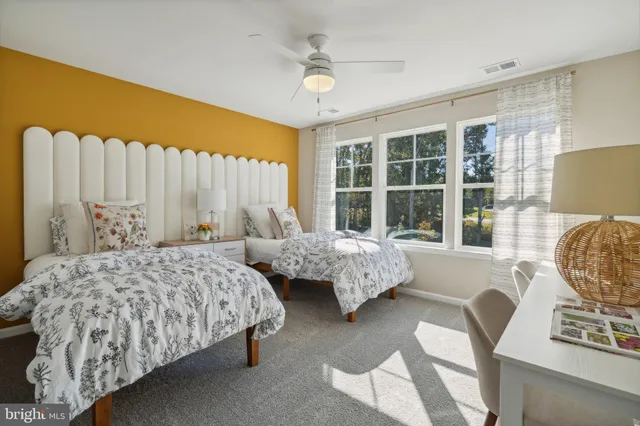 a bedroom with two beds and a large window