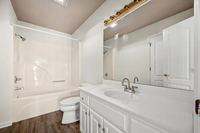 a bathroom with a sink a toilet and a large mirror