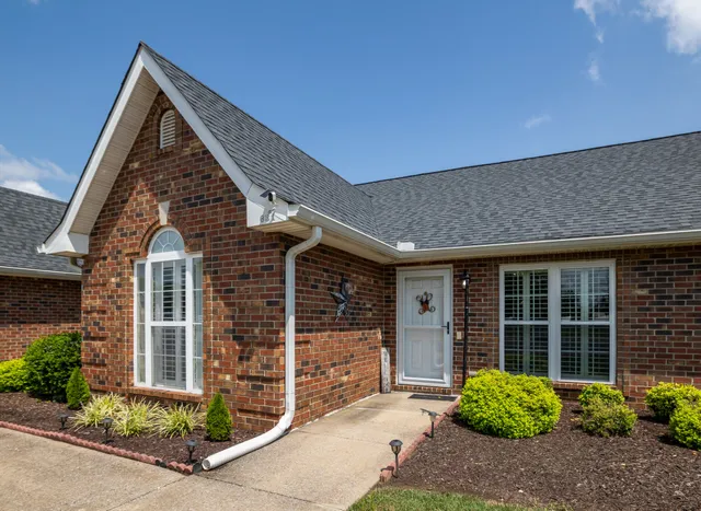 front view of a house with a large window and potted plants