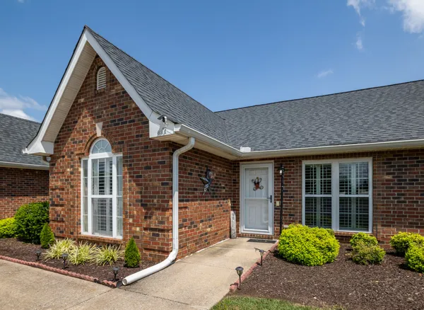 front view of a house with a large window and potted plants