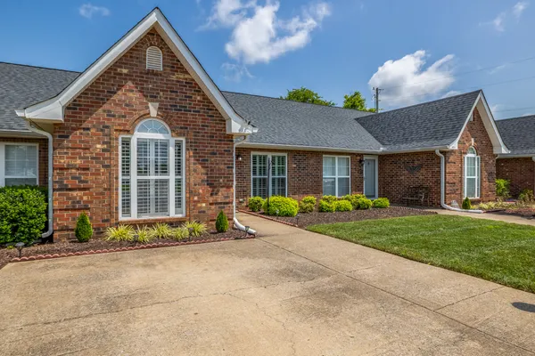 a front view of a house with a yard and outdoor seating