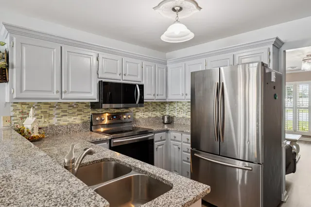 a kitchen with stainless steel appliances granite countertop a refrigerator stove and sink