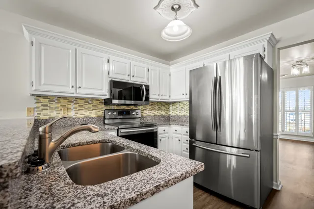 a kitchen with stainless steel appliances granite countertop a refrigerator a sink a stove a microwave and island