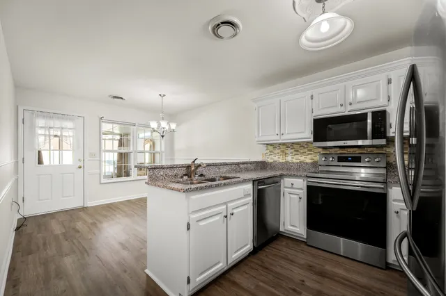 a kitchen with stainless steel appliances granite countertop a stove and a sink