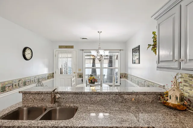 a view of a kitchen with granite countertop a sink and a window