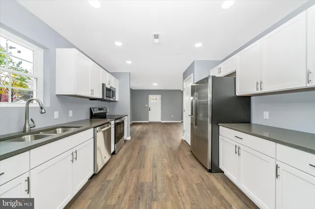 a kitchen with stainless steel appliances a refrigerator sink and cabinets