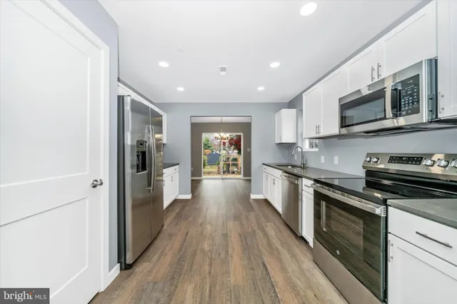 a large kitchen with stainless steel appliances granite countertop a stove and a refrigerator