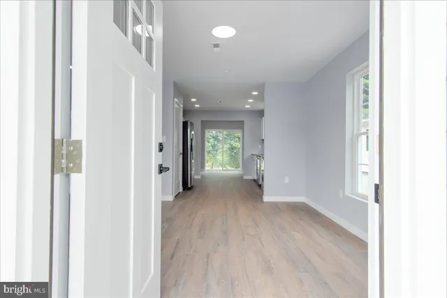 a view of a hallway with wooden floor and staircase