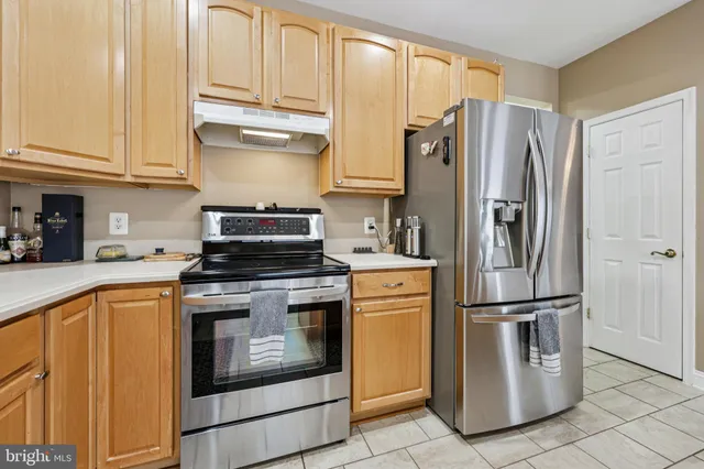 a kitchen with stainless steel appliances granite countertop a refrigerator a stove and a sink