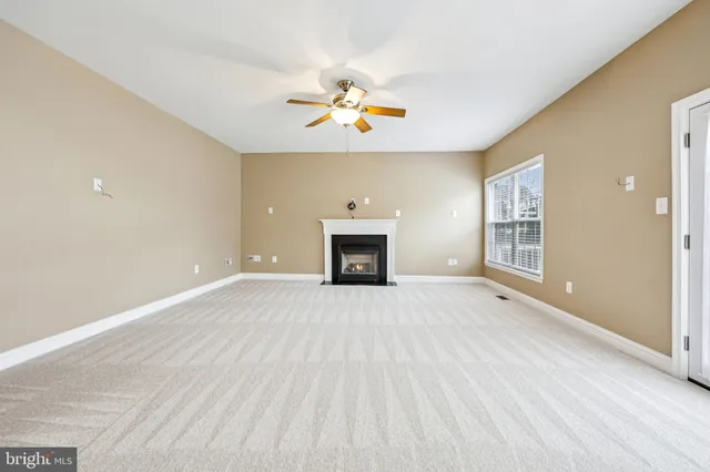 a view of an empty room with a fireplace and a window