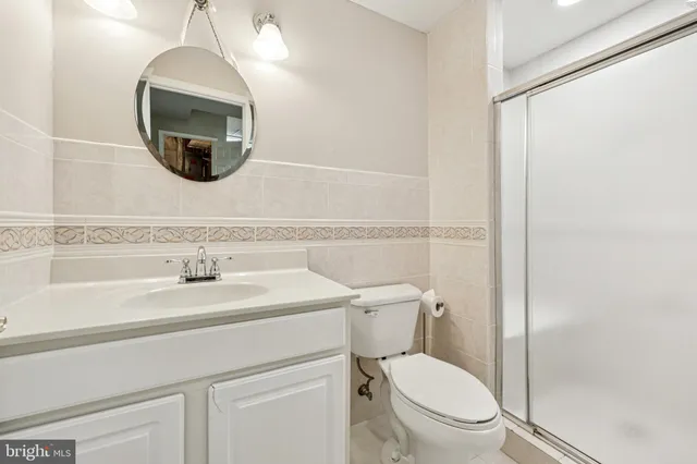 a bathroom with a toilet a sink and mirror
