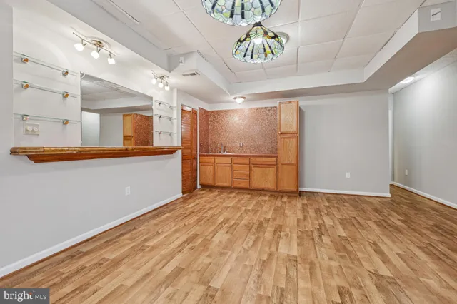 a view of a refrigerator in kitchen and an empty room
