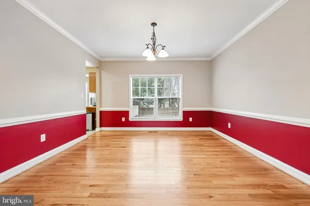 a view of empty room with window and chandelier fan