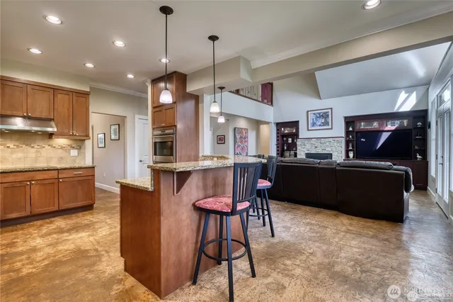 a kitchen with stainless steel appliances kitchen island granite countertop a refrigerator a stove a sink dishwasher with a dining table and chairs