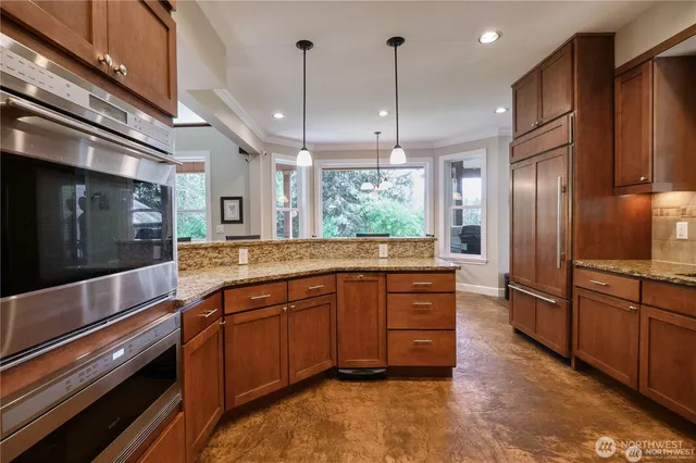 a kitchen with stainless steel appliances granite countertop a sink a stove and a refrigerator