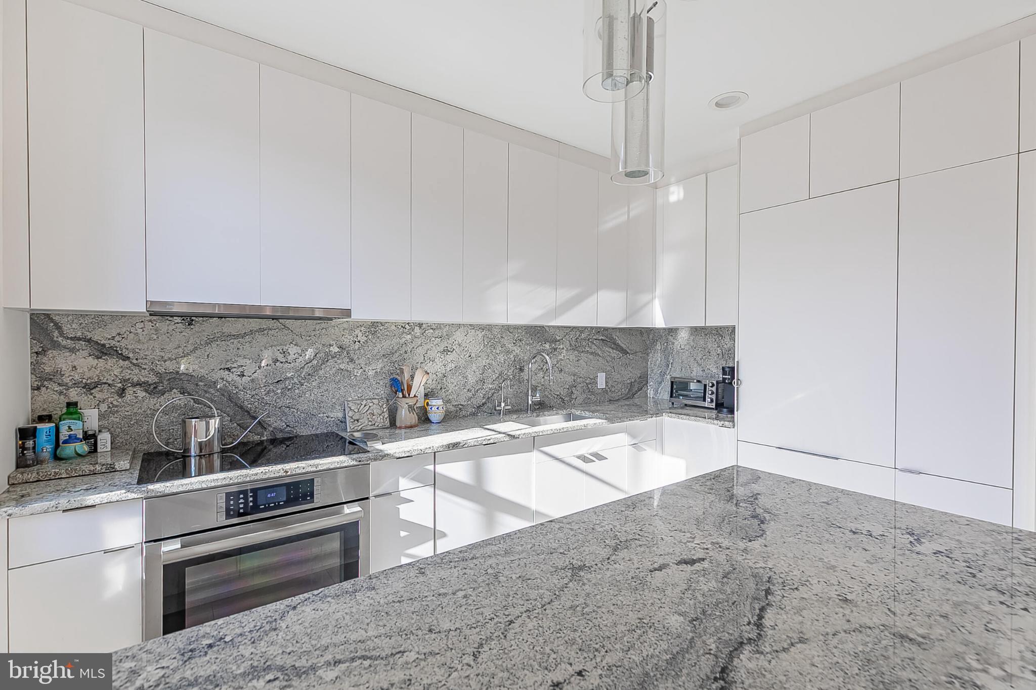 1517 30th Street Northwest, Unit C11 Washington, DC 20007 - Photo 11 of 33 a kitchen with granite countertop a sink and cabinets