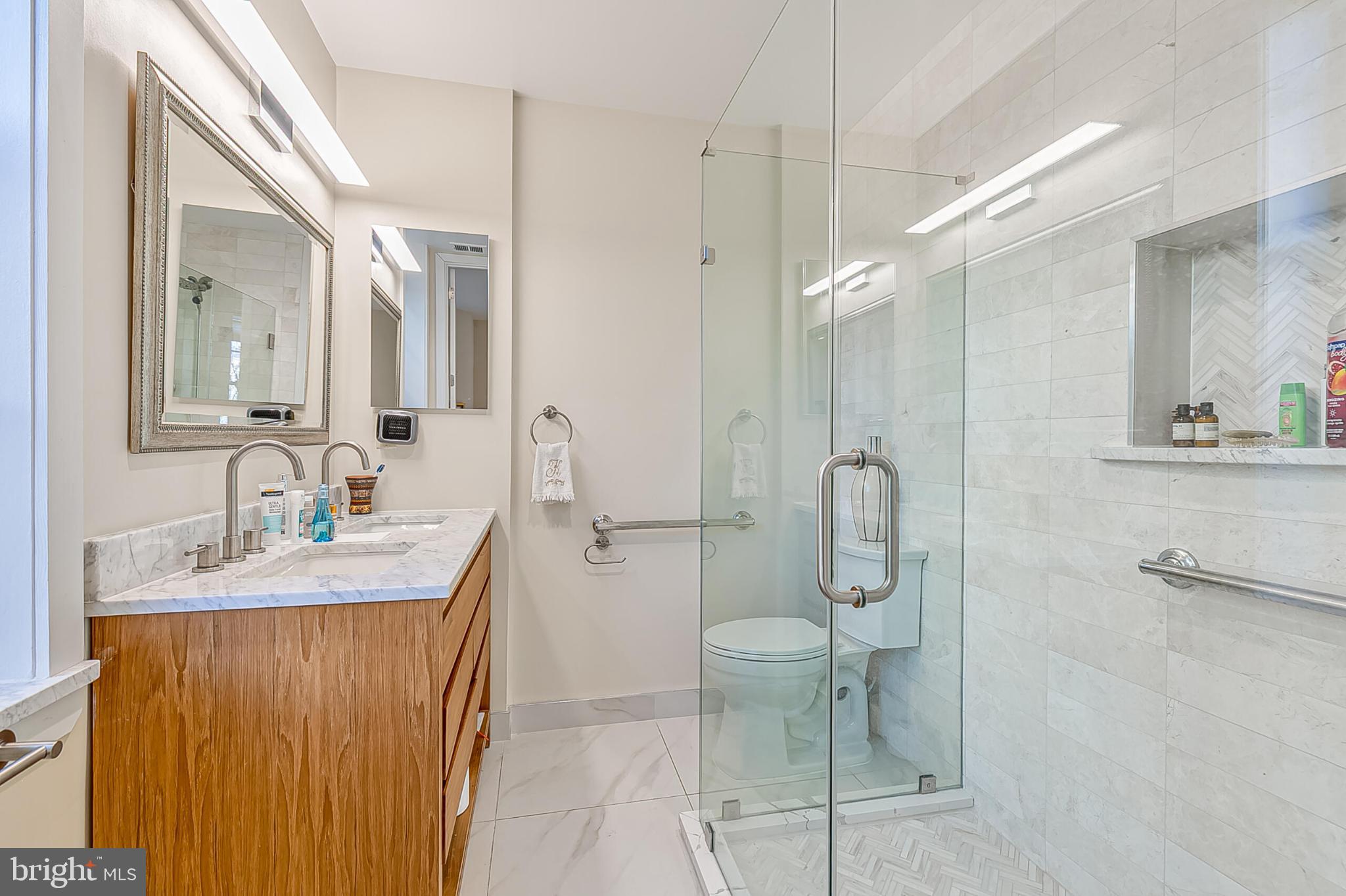 1517 30th Street Northwest, Unit C11 Washington, DC 20007 - Photo 21 of 33 a bathroom with a granite countertop sink a toilet and shower