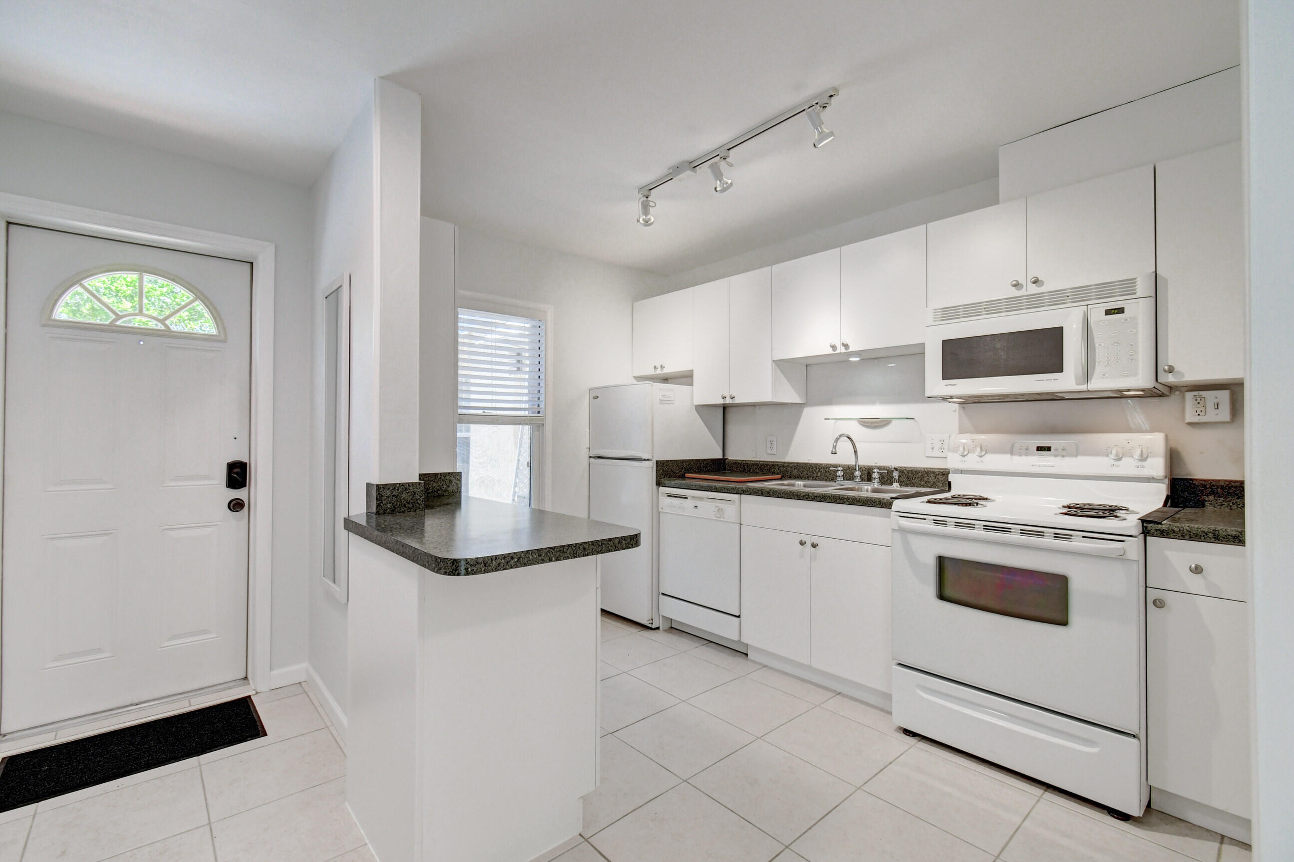 4 Gibbs Road, Unit 1 Boynton Beach, FL 33435 - Photo 11 of 43 a kitchen with granite countertop white cabinets and white appliances