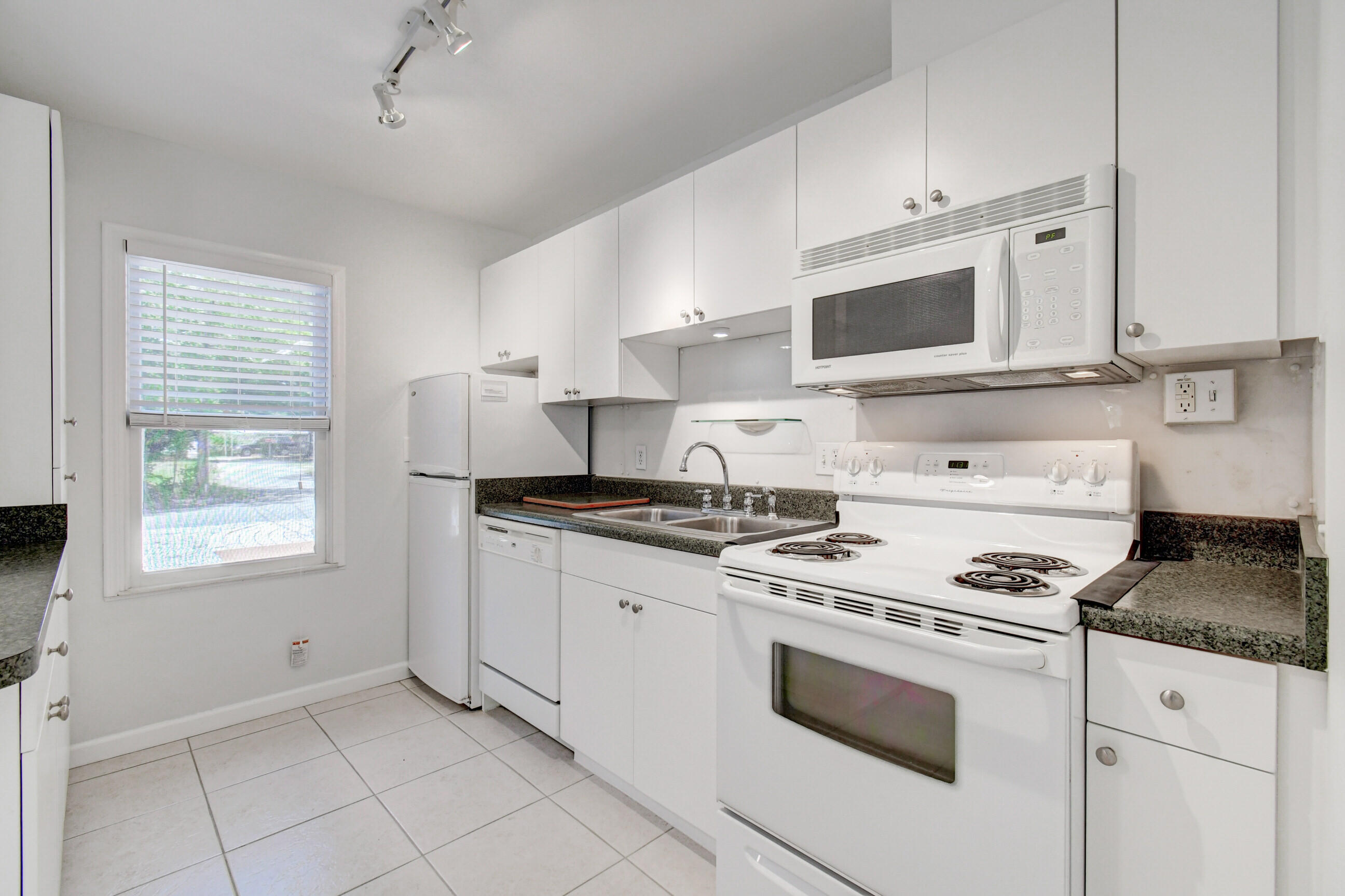 4 Gibbs Road, Unit 1 Boynton Beach, FL 33435 - Photo 12 of 43 a kitchen with granite countertop white cabinets and white appliances