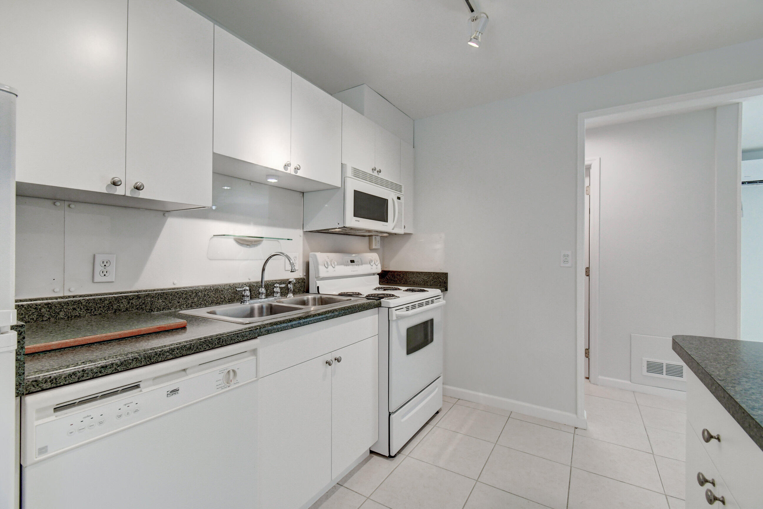 4 Gibbs Road, Unit 1 Boynton Beach, FL 33435 - Photo 14 of 43 a kitchen with granite countertop white cabinets and white appliances