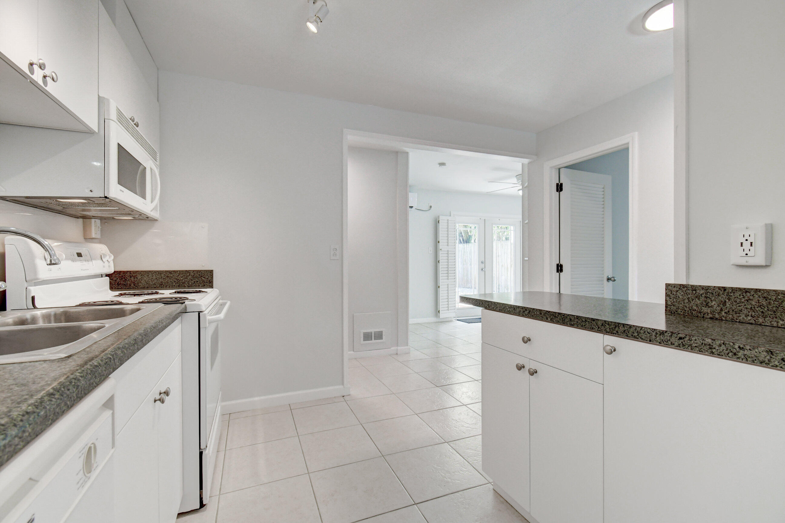 4 Gibbs Road, Unit 1 Boynton Beach, FL 33435 - Photo 15 of 43 a kitchen with granite countertop a sink and a stove