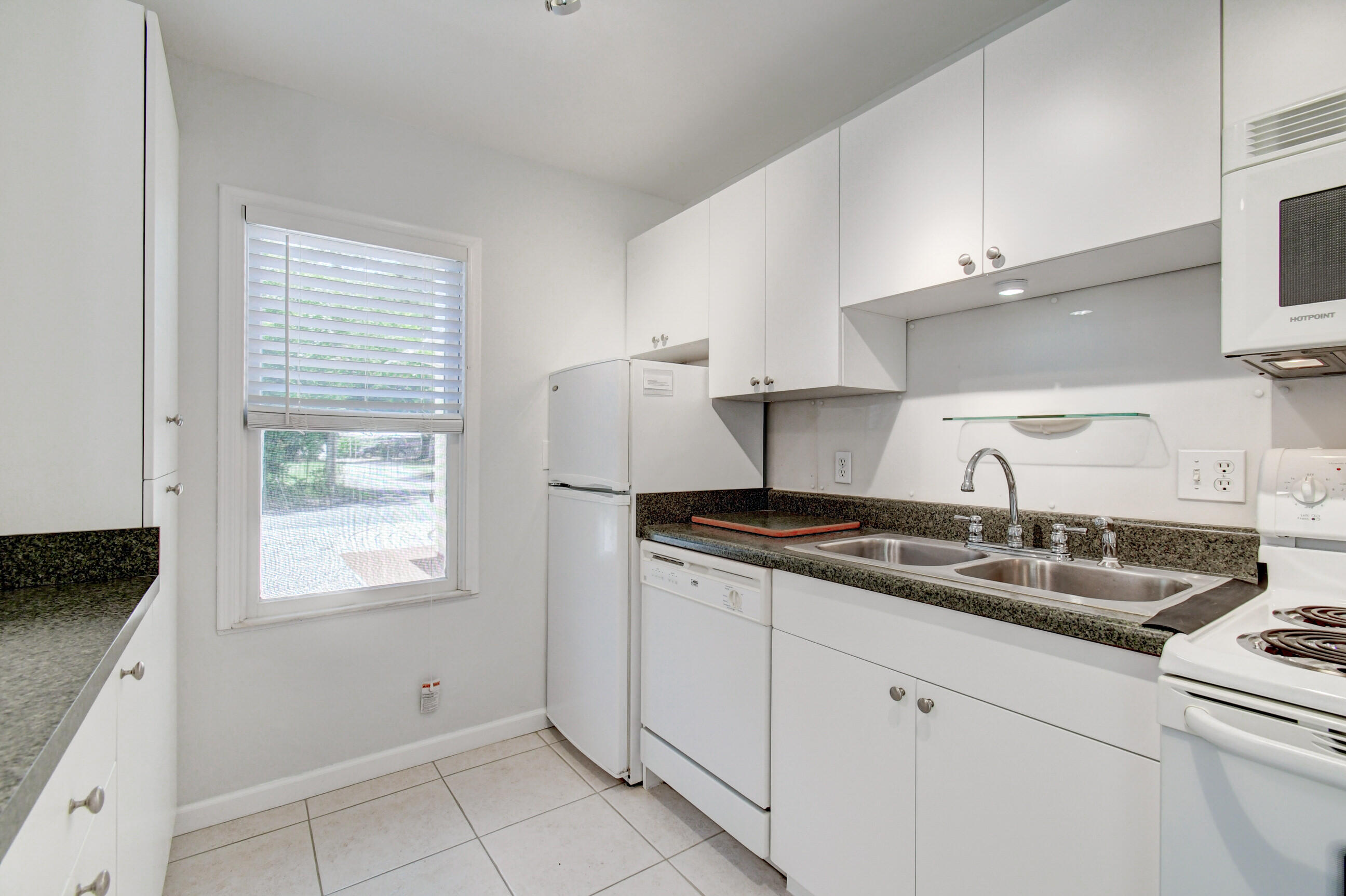 4 Gibbs Road, Unit 1 Boynton Beach, FL 33435 - Photo 16 of 43 a kitchen with granite countertop white cabinets and a sink