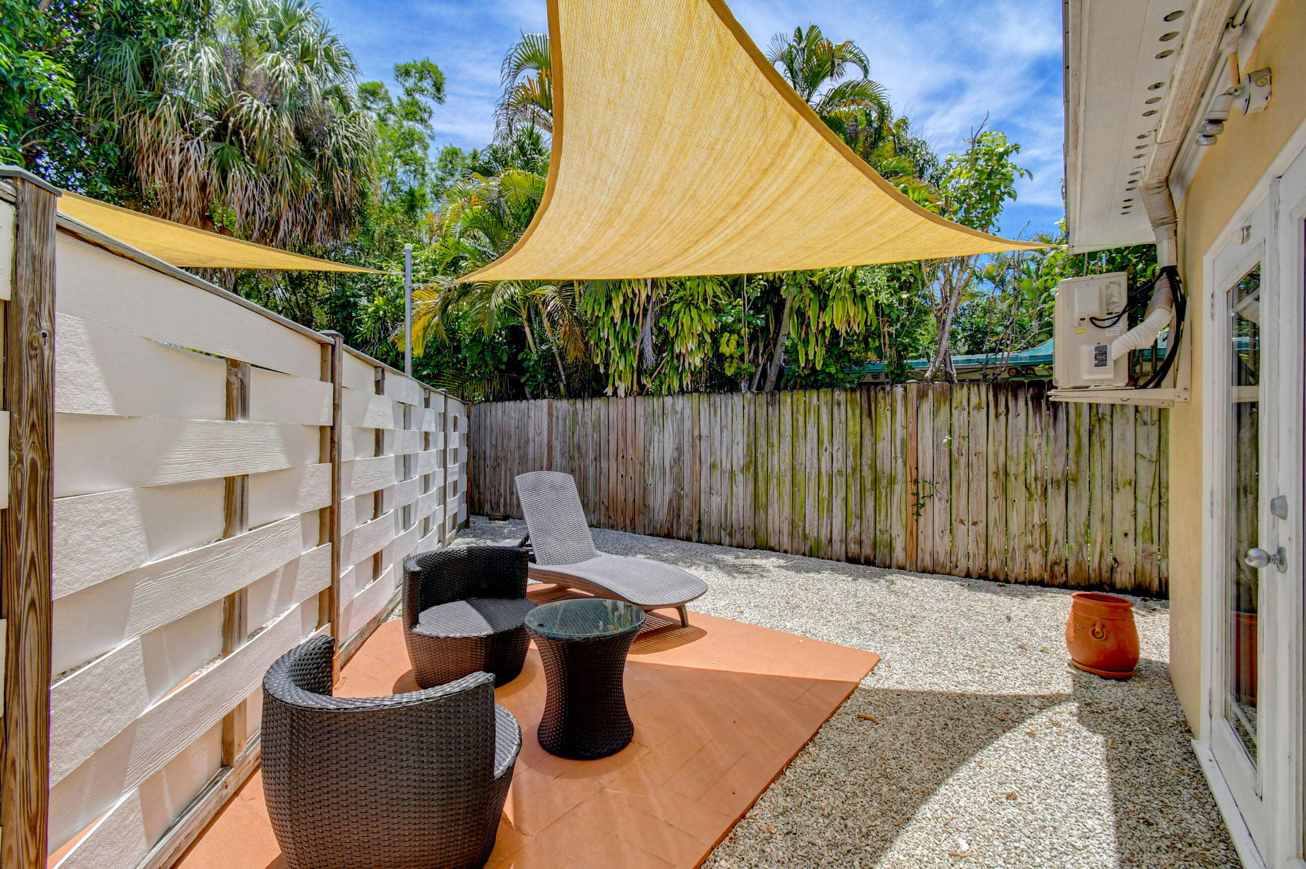 4 Gibbs Road, Unit 1 Boynton Beach, FL 33435 - Photo 28 of 43 a backyard of a house with wooden floor a yard and outdoor seating