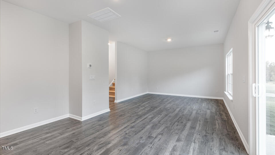 73 Stone Apiary Drive Angier, NC 27501 - Photo 12 of 32 a view of an empty room with wooden floor and a window
